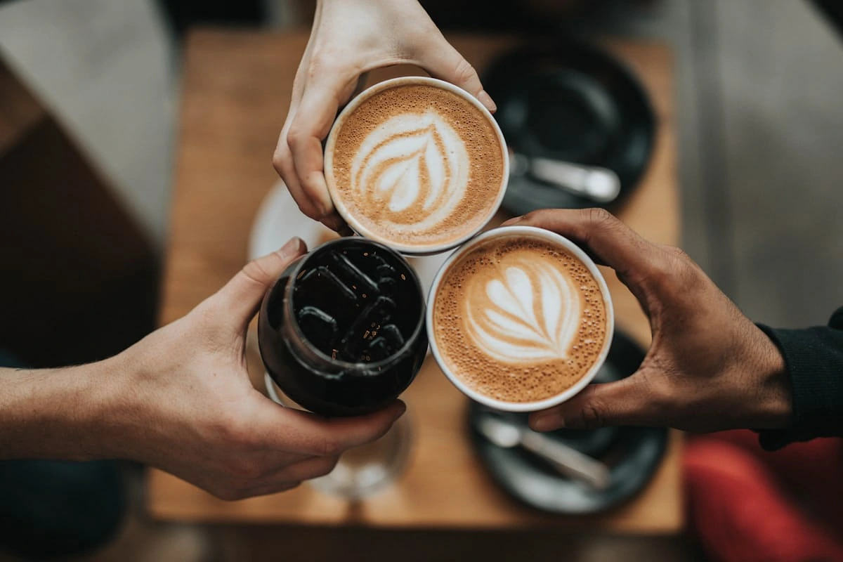 Három latte art kávé baráti találkozóhoz